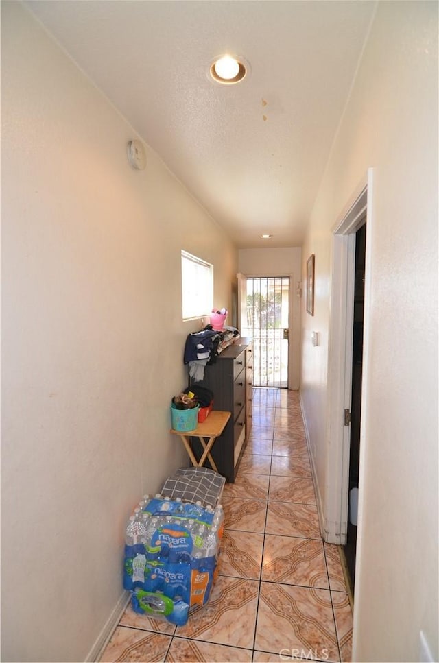 corridor with recessed lighting, baseboards, and light tile patterned flooring