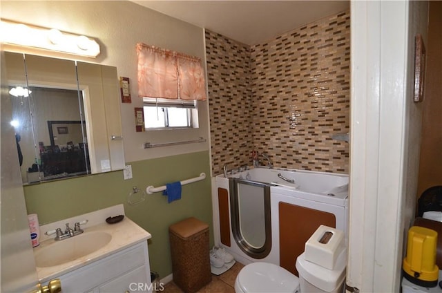 bathroom with a garden tub, vanity, and toilet