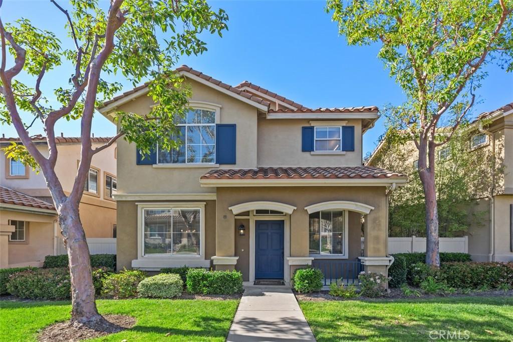 view of front of house featuring a tile roof, a front yard, stucco siding, and fence