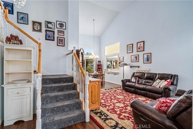 living room featuring baseboards, stairway, a notable chandelier, high vaulted ceiling, and dark wood-style flooring