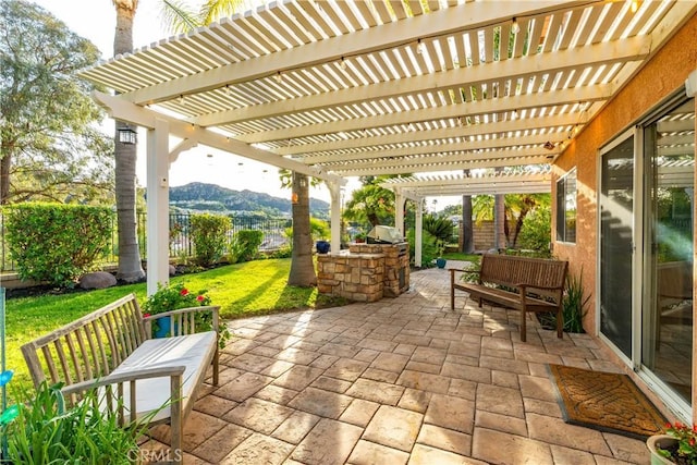 view of patio / terrace featuring exterior kitchen, a mountain view, area for grilling, and a pergola