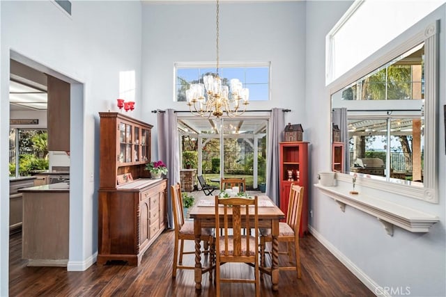 dining area with visible vents, a notable chandelier, dark wood finished floors, a high ceiling, and a healthy amount of sunlight