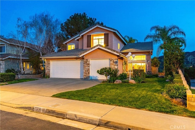 view of front of home with stucco siding, driveway, a front lawn, stone siding, and a garage