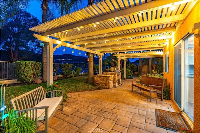 view of patio with area for grilling, fence, and a pergola