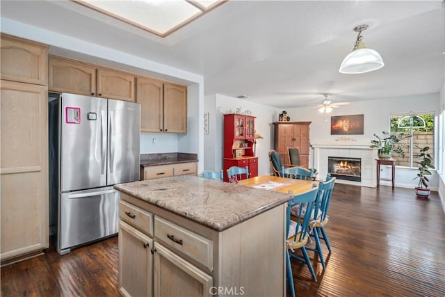 kitchen with dark wood finished floors, a fireplace, freestanding refrigerator, and a ceiling fan