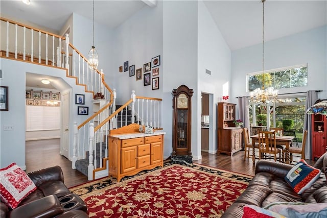 living room featuring a notable chandelier, high vaulted ceiling, stairs, and wood finished floors