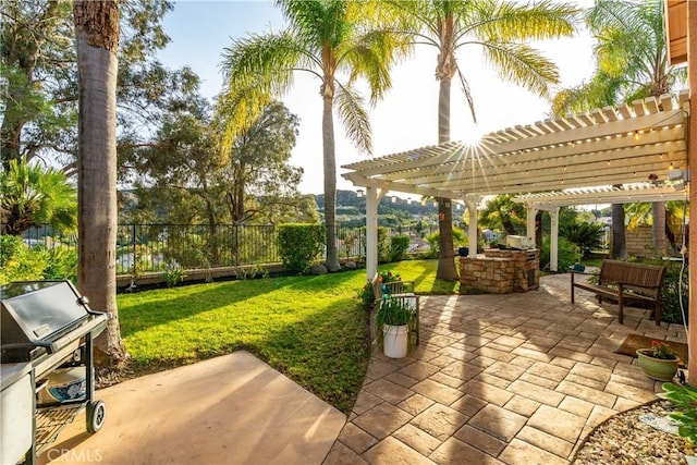 view of patio / terrace featuring an outdoor kitchen, a pergola, and a fenced backyard