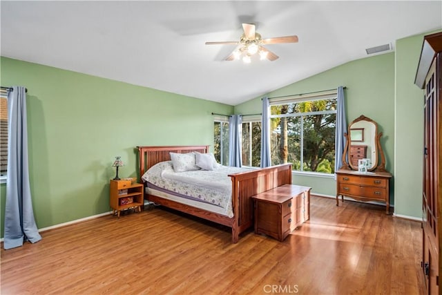 bedroom featuring visible vents, baseboards, lofted ceiling, and wood finished floors