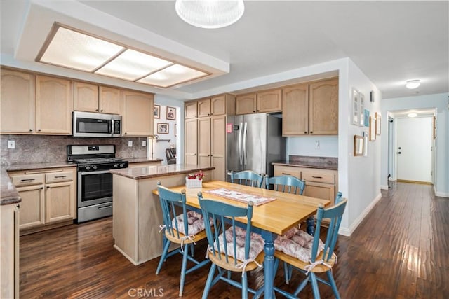 kitchen featuring dark wood-type flooring, baseboards, decorative backsplash, appliances with stainless steel finishes, and stone countertops