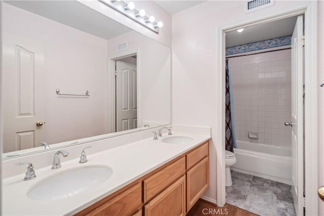 full bath with a sink, visible vents, toilet, and double vanity