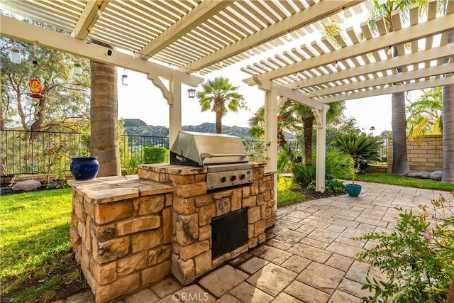 view of patio with grilling area, an outdoor kitchen, a fenced backyard, and a pergola