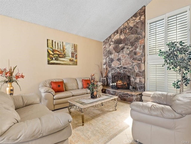 tiled living room featuring a textured ceiling, a stone fireplace, and vaulted ceiling