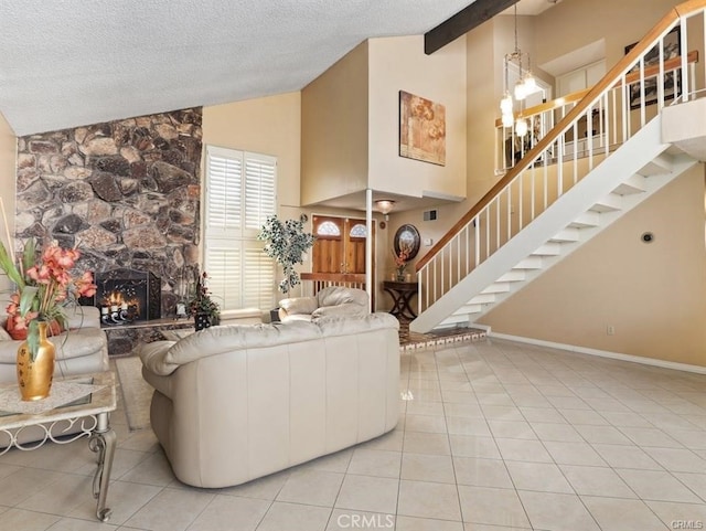 tiled living area with high vaulted ceiling, a textured ceiling, a stone fireplace, baseboards, and stairs