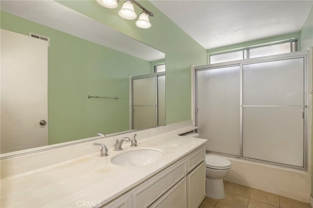 full bath featuring vanity, visible vents, shower / bath combination with glass door, tile patterned flooring, and toilet