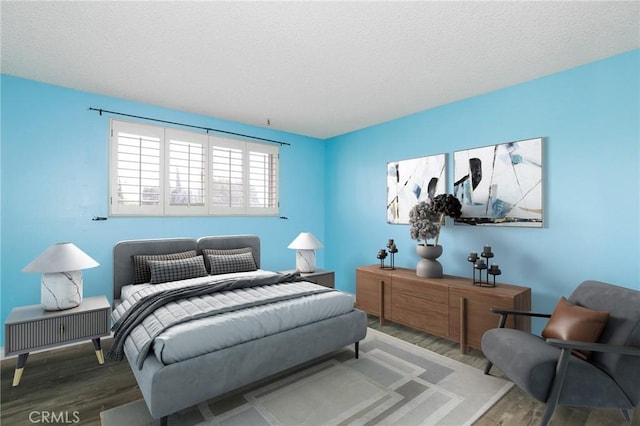 bedroom with a textured ceiling and wood finished floors