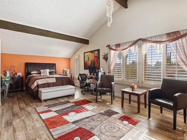 bedroom featuring a textured ceiling, vaulted ceiling with beams, baseboards, and wood finished floors