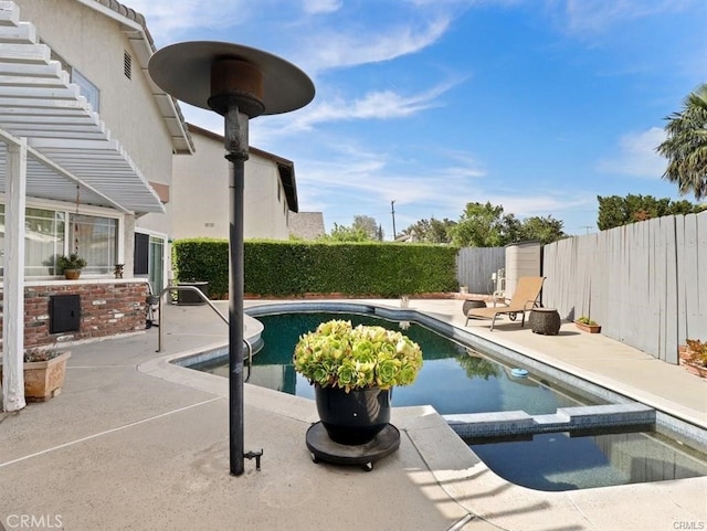 view of swimming pool featuring a patio, a fenced backyard, and a pool with connected hot tub