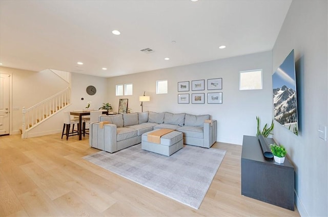 living room with visible vents, baseboards, stairs, recessed lighting, and light wood-style floors