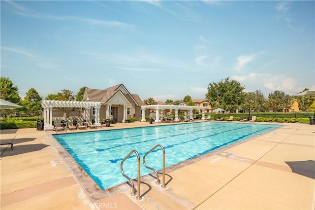 community pool featuring a patio area, a pergola, and fence