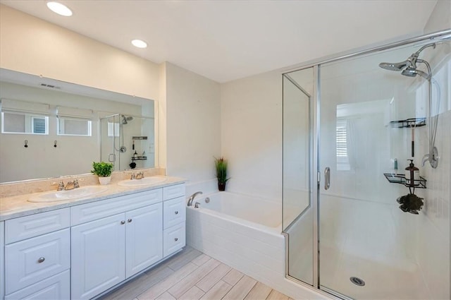 bathroom with a shower stall, a bath, double vanity, and a sink