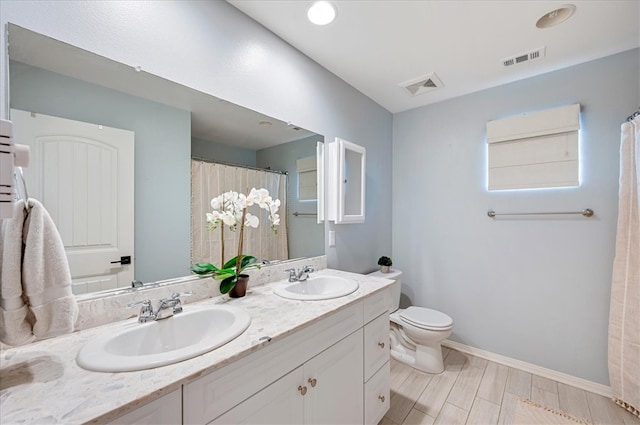 full bathroom featuring double vanity, toilet, visible vents, and a sink