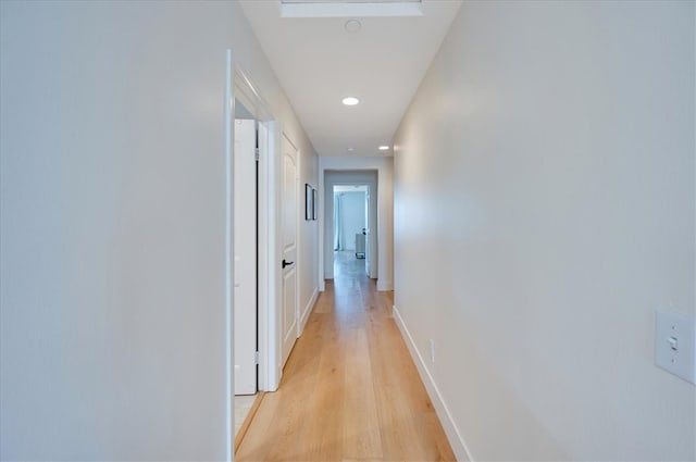 corridor with recessed lighting, light wood-style floors, and baseboards