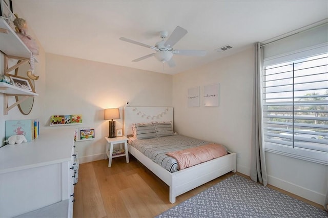 bedroom featuring a ceiling fan, light wood-style flooring, baseboards, and visible vents