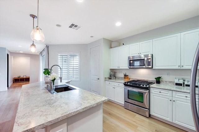 kitchen featuring a sink, stainless steel appliances, visible vents, and white cabinets