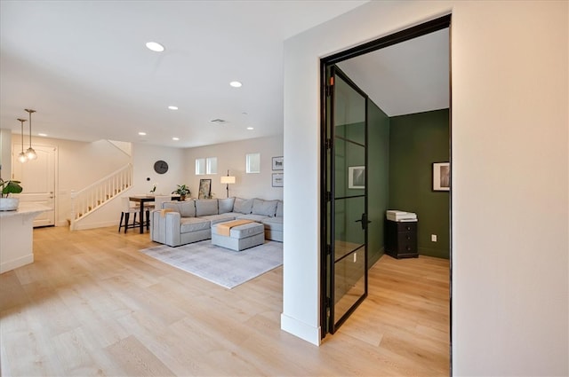 living area with stairway, recessed lighting, light wood-type flooring, and baseboards