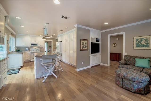 kitchen featuring visible vents, white appliances, white cabinets, and crown molding