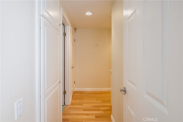 corridor featuring light wood finished floors, recessed lighting, and baseboards