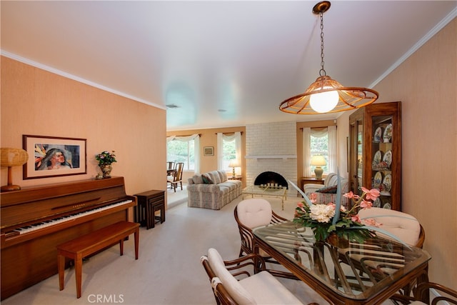 dining room featuring light carpet, plenty of natural light, a brick fireplace, and crown molding