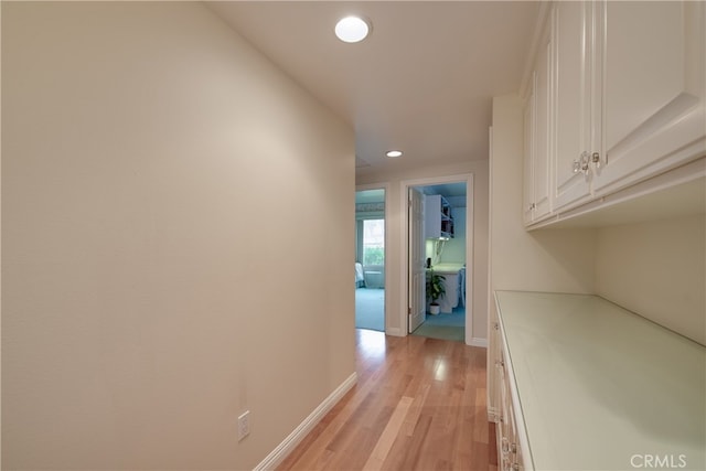 hallway featuring recessed lighting, baseboards, and light wood-style floors