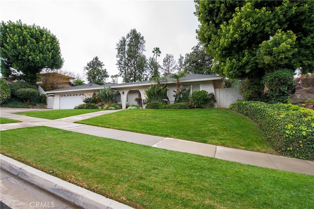 single story home with a front yard, fence, driveway, stucco siding, and a garage