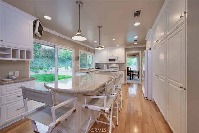 kitchen featuring visible vents, ornamental molding, white cabinetry, white appliances, and light wood-style floors