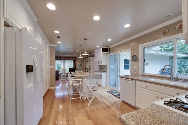 kitchen featuring white appliances, white cabinetry, crown molding, and a sink