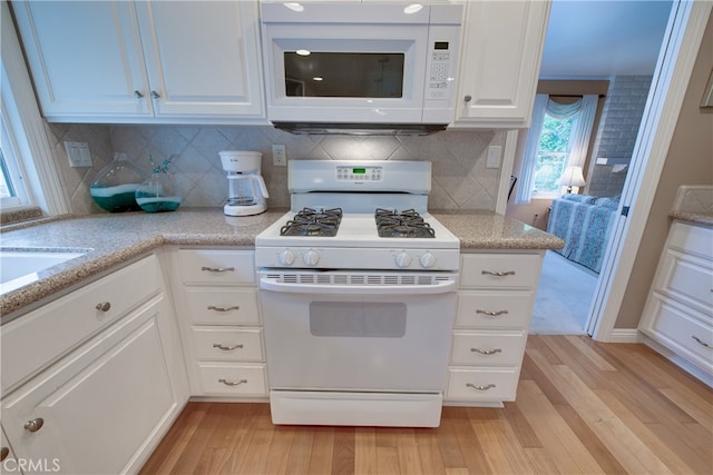 kitchen featuring decorative backsplash, white appliances, white cabinets, and light wood-type flooring