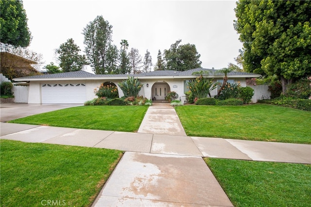 single story home with stucco siding, a front lawn, french doors, concrete driveway, and a garage