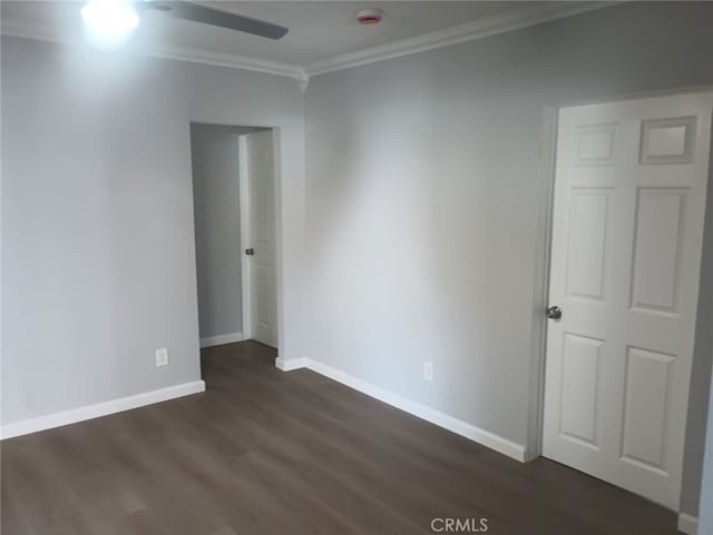 unfurnished room with ceiling fan, dark wood-style floors, baseboards, and ornamental molding