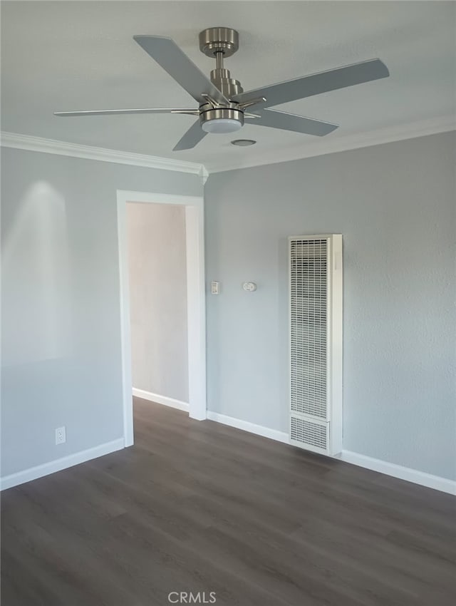 empty room with a heating unit, crown molding, baseboards, and dark wood-style flooring