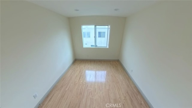 empty room featuring baseboards and light wood-style flooring