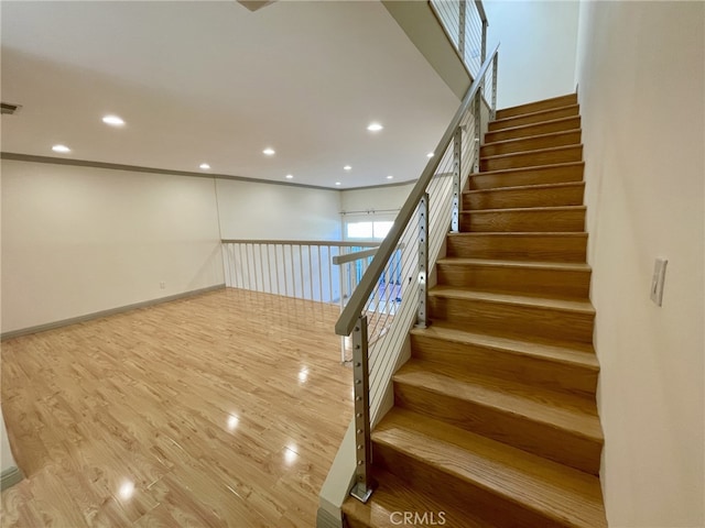 staircase featuring recessed lighting, visible vents, and wood finished floors