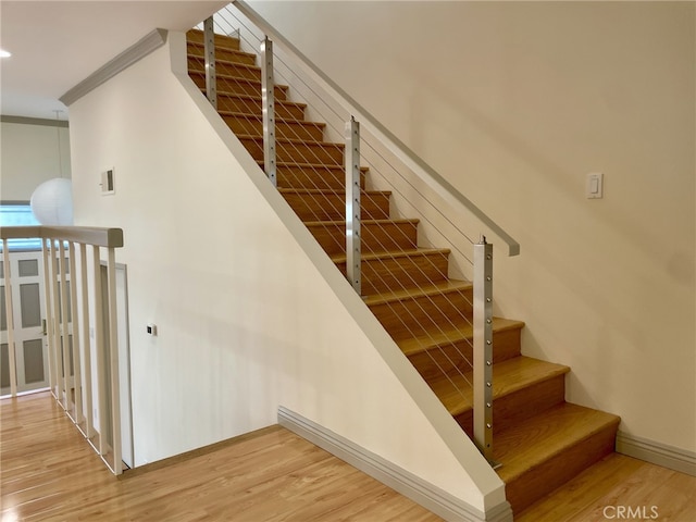 stairway featuring visible vents, baseboards, and wood finished floors