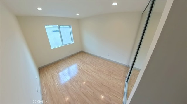 spare room with light wood-style flooring, recessed lighting, and baseboards