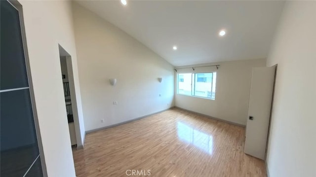 unfurnished room with recessed lighting, baseboards, light wood-type flooring, and high vaulted ceiling