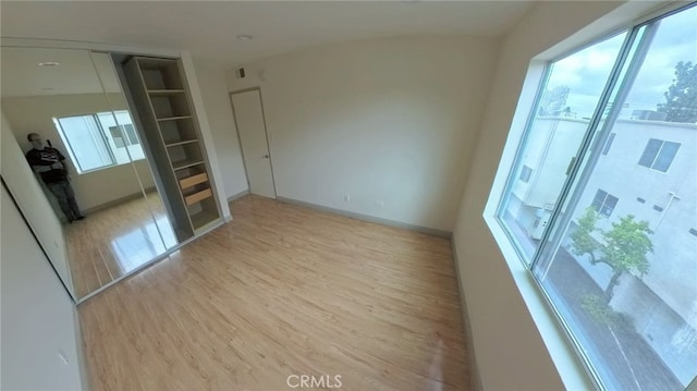 spare room featuring baseboards and light wood-style floors