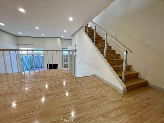 stairs featuring recessed lighting, crown molding, baseboards, and wood finished floors