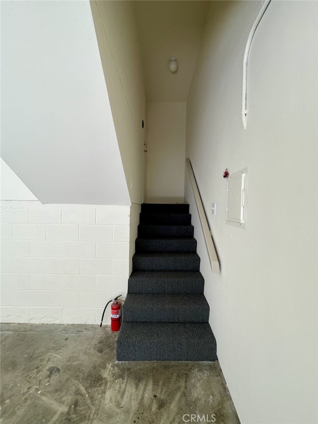 stairway with unfinished concrete flooring