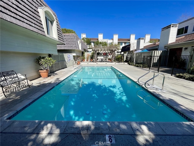 pool with a patio and fence