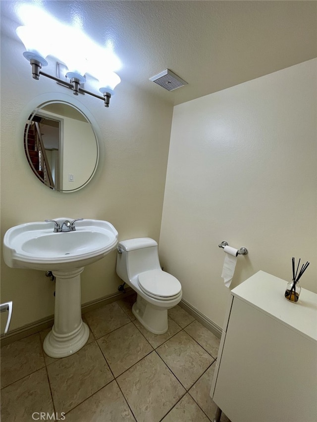 bathroom with tile patterned floors, visible vents, baseboards, and toilet